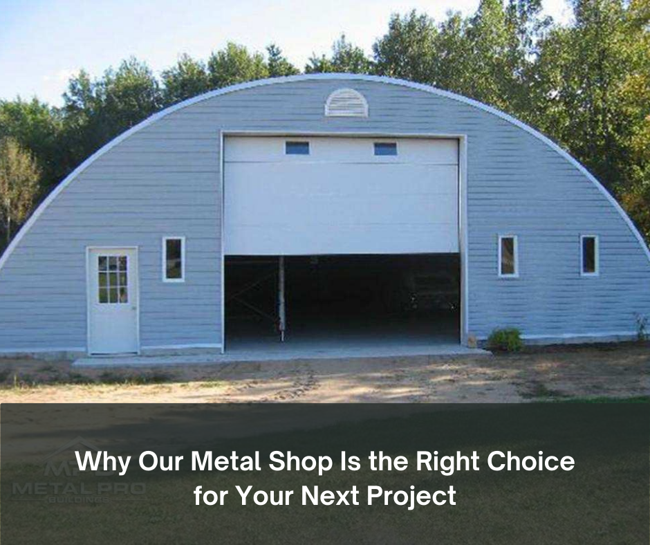 Large gray arched metal shop building with white garage door and side entry, surrounded by trees