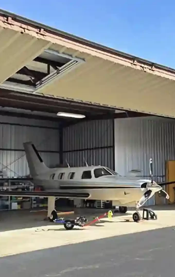 plane parked inside a steel aircraft hangar